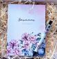Preview: Personalisierter Notizblock mit Namen 'Susanne, Fotografin' und passendem Stift, beide mit floralen Motiven dekoriert, stilvoll in Holzwolle verpackt.