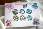 Preview: Gender-Reveal-Karte im A6-Format mit 6 holografischen Rubbelstickern, verziert mit liebevollen Baby-Illustrationen und Ballon-Designs, ideal für stilvolle Geschlechtsverkündung.