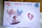 Preview: Geschlecht verkünden - Rubbelkarte in Größe A6 mit liebevollem Design, Baby auf einer Schaukel mit rosa und blauen Luftballons, enthülltes Bild mit rosa Fußabdrücken zeigt, dass es ein Mädchen wird. Perfekt für Gender-Reveal-Überraschungen.