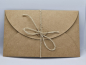Preview: Umschlag aus Kraftpapier mit Herzverschluss – perfekt abgestimmt auf die Rubbelkarte.