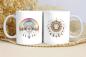 Preview: Zwei weiße Keramikbecher mit boho-inspirierten Motiven: Der linke Becher zeigt einen Regenbogen mit feinen Mandala-Details und hängenden Federn, der rechte Becher ein Sonnengesicht, umgeben von Blatt- und Federornamenten. Ideale Geschenkidee für Liebhaber
