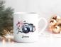Preview: Personalisierte Fotografin-Tasse mit Aquarellkamera und rosa Blumen, weihnachtlich dekoriert mit Tannenzweigen und goldenen Kugeln.