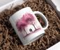 Preview: Weiße Tasse mit einem romantischen Aquarellmotiv eines Paares, das Hand in Hand unter rosafarbenen blühenden Bäumen spaziert. Ein zartes und stimmungsvolles Design, ideal als Geschenk für besondere Anlässe oder als Erinnerung an gemeinsame Momente.