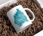 Preview: Weiße Tasse mit dem Sternzeichen-Symbol Löwe auf einem sternenklaren, türkisfarbenen Hintergrund. Ein perfektes, personalisierbares Geschenk für Astrologie-Fans und Liebhaber des Sternzeichens Löwe.