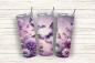 Preview: Thermobecher auf einem weißen, strukturierten Holzhintergrund. Das Design zeigt elegante lila Schmetterlinge und florale Elemente in Violett- und Fliedertönen, mit großen Blumen und Blattakzenten auf einem weichen, pastellfarbenen Hintergrund.