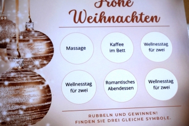 Weihnachts-Rubbelkarte und Umschlag in edlem Design, präsentiert auf einem festlichen Hintergrund.