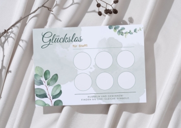 Personalisierte Glückslos-Karte mit dem Namen „Steffi“ im Eukalyptus-Design mit grünen Blättern und zartem Aquarellhintergrund. Die Karte liegt auf hellem Stoff neben einem Zweig und zeigt sechs leere Rubbelfelder.