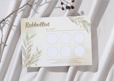 Personalisierte Rubbellos-Karte mit dem Namen „Steffi“ im eleganten Boho-Gold-Design mit zarten Blättern und goldenen Akzenten. Die Karte liegt auf weichem, hellem Stoff mit dekorativem Zweig. Sechs leere Rubbelfelder sind sichtbar.