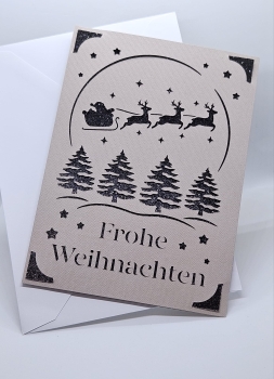 Handgefertigte Weihnachtskarte in Grau mit schwarzem Glitzerhintergrund. Filigranes Design zeigt den Weihnachtsmann im Schlitten, gezogen von Rentieren, sowie Weihnachtsbäume und Sterne. Karte wird mit einem passenden weißen Umschlag geliefert.