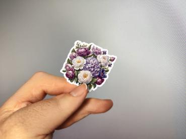 Hand, die einen Blumenaufkleber mit lila und weißen Blüten hält, gestaltet von DreamArt VM.
