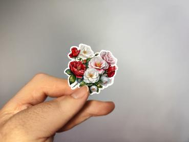 Hand, die einen Blumenaufkleber mit roten und weißen Blüten hält, gestaltet von DreamArt VM.