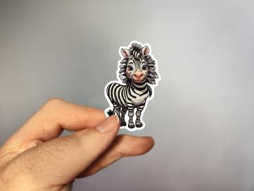Hand, die einen Aufkleber in Form eines niedlichen Zebras hält, gestaltet von DreamArt VM.
