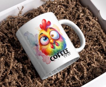 Weißer Kaffeebecher mit buntem, lustigem Hühnerdesign und dem Text 'Coffee first', präsentiert in einer Geschenkbox mit Papierfüllmaterial. Perfektes Geschenk für humorvolle Kaffeeliebhaber.