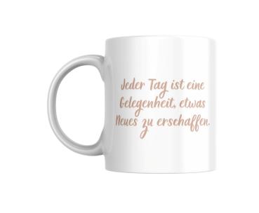 Weiße Tasse mit dem Motivtext ‚Jeder Tag ist eine Gelegenheit, etwas Neues zu erschaffen.‘ in einem sanften Beigeton auf der Vorderseite. Das Design ist schlicht und motivierend, perfekt als tägliche Erinnerung.