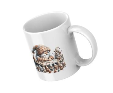 Weiße Tasse mit einer Illustration eines kleinen, bärtigen Handwerkergnoms in einem gestrickten Mützchen, der an einem Tisch voller kleiner Skulpturen und Handwerksmaterialien sitzt. Umgeben von weiteren Gnomenfiguren und kreativen Werkzeugen, symbolisier