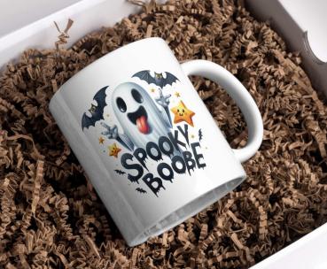 Preview: Halloween-Tassenkollektion – Gruselige & Lustige Designs | 5 Einzigartige Varianten Preview: Weiße Tasse mit Halloween-Motiv eines fröhlichen Geistes, der seine Zunge herausstreckt, umgeben von Fledermäusen und Sternen, mit dem Text ‚Spooky Boo-be‘. Perfektes Geschenk für Halloween-Fans, die ein humorvolles Design schätzen.