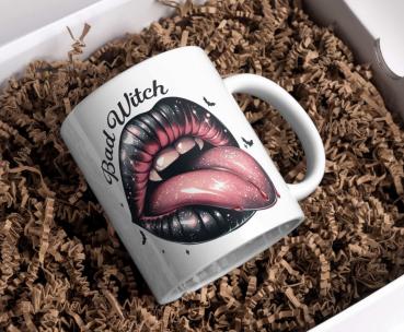 Preview: Halloween-Tasse „Bad Witch“ und „Halloween Yall“ Preview: Weiße Keramiktasse mit dem Halloween-Design 'Bad Witch'. Das Motiv zeigt große schwarze Lippen mit herausgestreckter, rosa Zunge, umgeben von kleinen Fledermäusen und funkelnden Details. Perfekt für Halloween-Fans und Liebhaber eines frechen, mystischen S