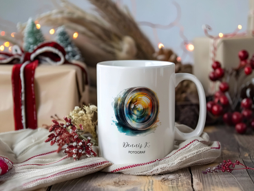 Personalisierte Fotografen-Tasse mit bunter Kameralinse, weihnachtlich dekoriert mit Geschenken, Lichterkette und winterlichen Naturmaterialien.