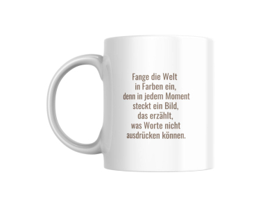 Eine weiße Keramiktasse mit einem inspirierenden Zitat, das in eleganter, brauner Schrift geschrieben ist. Der Text lautet: "Fange die Welt in Farben ein, denn in jedem Moment steckt ein Bild, das erzählt, was Worte nicht ausdrücken können." Diese Tasse i