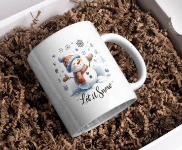 Weihnachtstasse mit fröhlichem Schneemann und dem Schriftzug 'Let it Snow'. Der Schneemann trägt eine winterliche Mütze und Schal und ist von Schneeflocken umgeben. Perfekt für warme Getränke zur Weihnachtszeit.