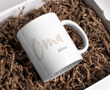 Preview: Personalisierte Oma Tasse in Beige mit Namen Silvia, dekorativ in umweltfreundlicher Verpackung arrangiert.