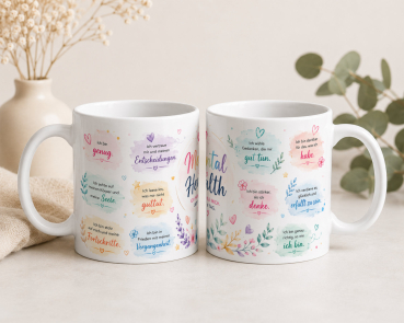 Preview: Zwei Ansichten einer weißen Keramiktasse mit umlaufendem Mental Health Design und deutschen Affirmationen auf hellem Untergrund mit dezenter Dekoration.