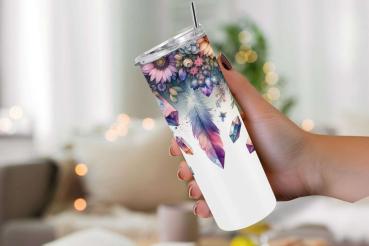 Hand hält einen eleganten Tumbler mit Blumen-, Feder- und Kristalldesign in leuchtenden Farben auf weißem Hintergrund. Hintergrund unscharf, im gemütlichen Wohnzimmerstil.