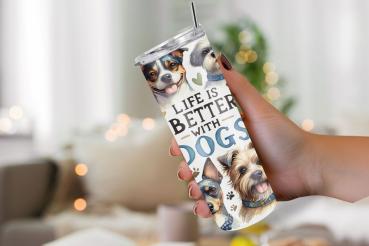 Ein Thermobecher mit dem Design „Life is Better with Dogs“, gehalten von einer Hand vor einem gemütlichen Hintergrund mit unscharfen Lichtern. Der Becher zeigt verschiedene Hunderassen, die fröhlich dreinschauen und mit bunten Schleifen dekoriert sind. Di