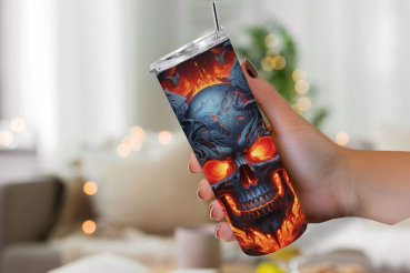 Hand hält einen Thermobecher mit Totenkopf-Design, das feurige und leuchtende Blau- und Rottöne zeigt. Der Becher hat einen silbernen Deckel mit Strohhalm. Im Hintergrund ist eine unscharfe, gemütliche Wohnzimmerszene mit warmem Bokeh-Lichteffekt.