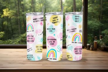 Drei weiße Thermobecher mit farbenfrohen, motivierenden Botschaften und Illustrationen von Regenbögen und Blättern. Enthält positive Sprüche wie 'Make today a good day', 'Follow your dreams' und 'Good vibes only'. Die Becher stehen vor einem Fenster mit W