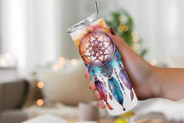 Hand hält einen Thermobecher mit detailreichem Traumfänger-Design, verziert mit bunten Federn und floralen Elementen im Boho-Stil. Das Bild vermittelt eine gemütliche Atmosphäre, perfekt für Liebhaber von Boho-Accessoires.