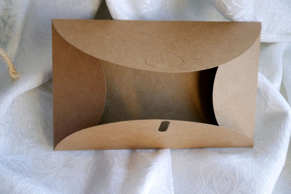 Offener Kraftpapier-Umschlag mit Herzverschluss, zeigt die hochwertige und nachhaltige Verpackung für Gender-Reveal-Karten. Perfekt für eine liebevolle Präsentation.