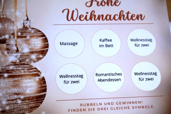 Weihnachts-Rubbelkarte und Umschlag in edlem Design, präsentiert auf einem festlichen Hintergrund.