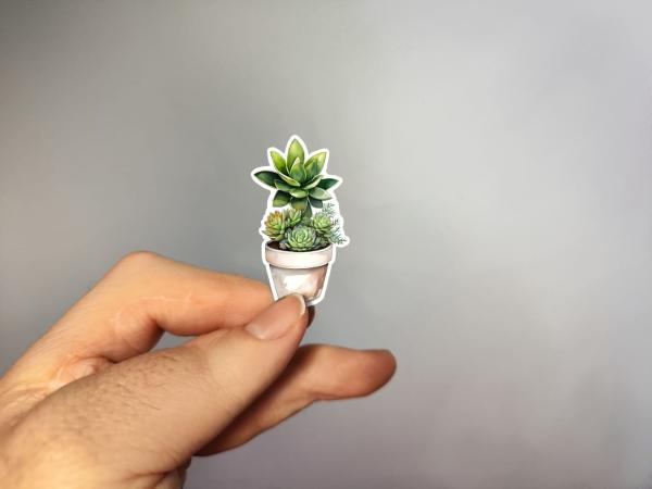 Kleiner Sticker mit Sukkulenten-Arrangement im Topf, handgefertigt im Aquarellstil – in der Hand gezeigt