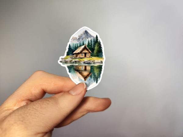 Kleiner handgemalter Aufkleber mit Bergkulisse und Seespiegelung – in der Hand gehalten, Aquarellstil
