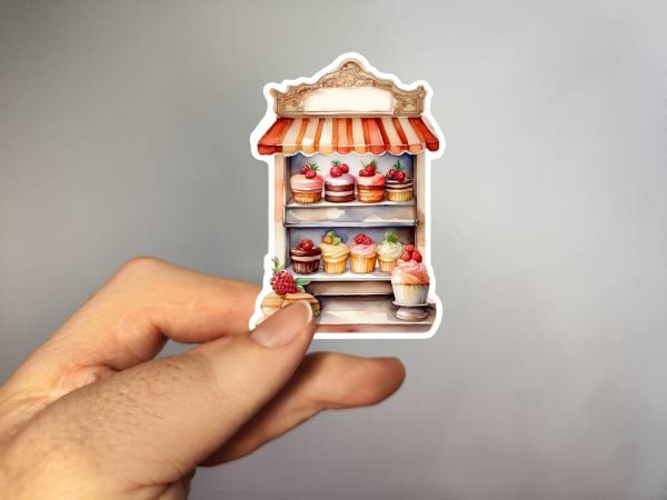 Handgefertigter Aufkleber eines kleinen Dessert-Stands mit köstlichen Cupcakes und Torten – Aquarellstil