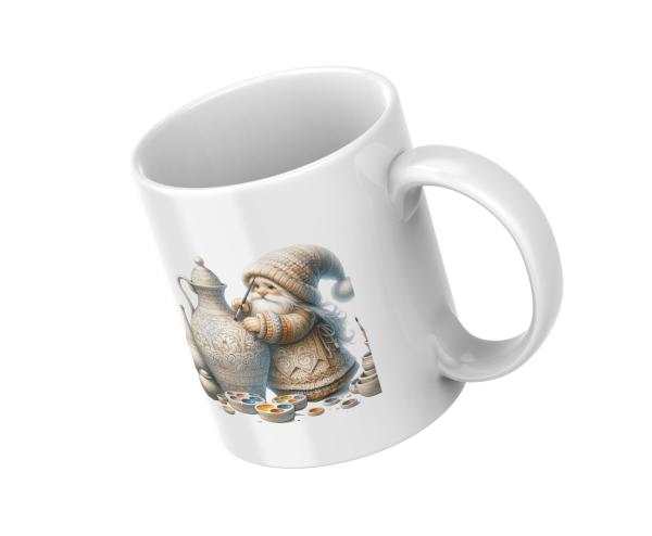 Weißer Kaffeebecher mit niedlichem Gnom-Design, der eine kunstvoll verzierte Kanne bemalt, umgeben von Farbpaletten. Der Becher ist in schräger Position dargestellt, ideal für kreative Seelen und Kunstliebhaber.