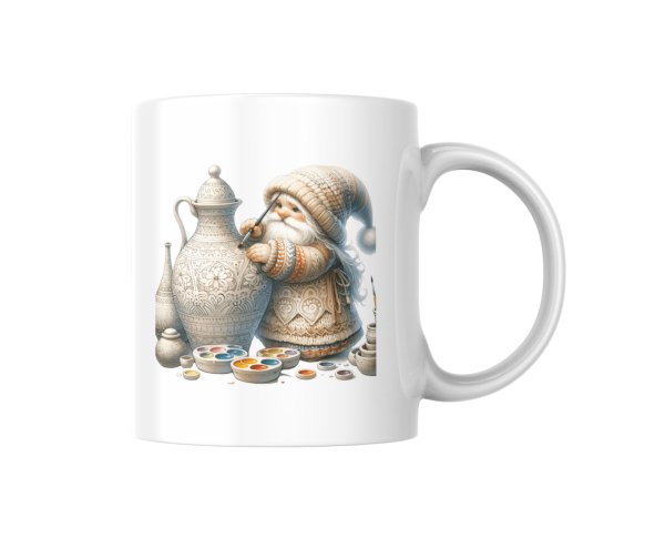 Weißer Kaffeebecher mit niedlichem Gnom-Design, der eine kunstvoll verzierte Kanne bemalt, umgeben von Farbpaletten. Perfekt für kreative Seelen und Kunstliebhaber als Geschenkidee.