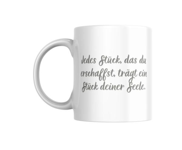 Weißer Kaffeebecher mit inspirierendem Spruch in deutscher Sprache: 'Jedes Stück, das du erschaffst, trägt ein Stück deiner Seele.' Perfekt für kreative Menschen und Kunsthandwerker.