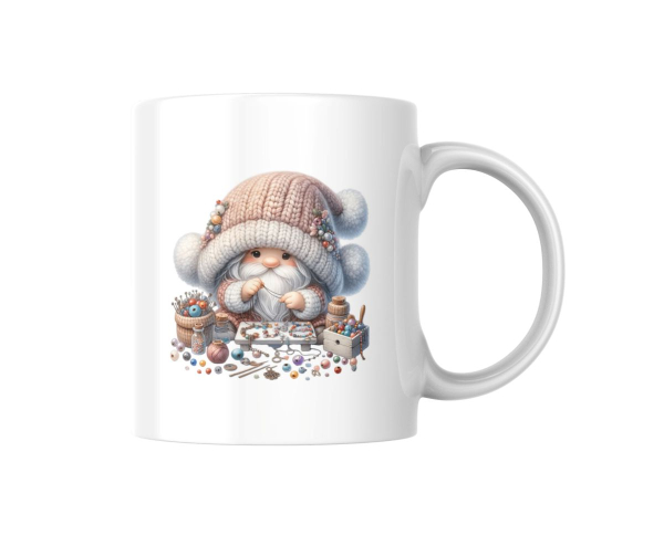 Weiße Tasse mit einem niedlichen Gnommotiv in der Mitte. Der Gnom trägt eine gestrickte Mütze und sitzt zwischen verschiedenen Bastelmaterialien wie Perlen und Nadeln. Perfekt für kreative Bastel- und Handarbeitsfans.