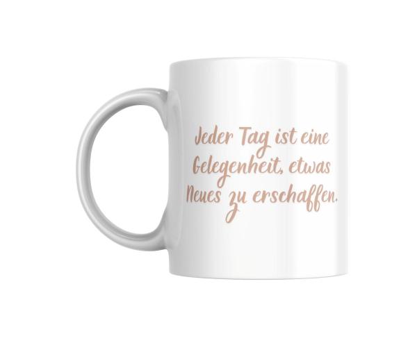 Weiße Tasse mit dem Motivtext ‚Jeder Tag ist eine Gelegenheit, etwas Neues zu erschaffen.‘ in einem sanften Beigeton auf der Vorderseite. Das Design ist schlicht und motivierend, perfekt als tägliche Erinnerung.