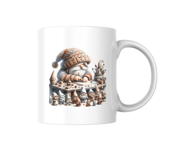 Weiße Tasse auf einem Holztisch mit einer Illustration eines kleinen, bärtigen Handwerkergnoms in einer gestrickten Mütze. Der Gnom sitzt an einem Tisch mit kleinen Skulpturen und Handwerksmaterialien, umgeben von weiteren Gnomenfiguren, die Liebe zum Det