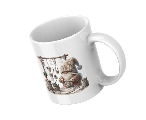 Ein weißer Keramikbecher, der schräg auf einem weißen Hintergrund steht. Der Becher zeigt ein Bild eines Zwergs, der gerade Makramee kreiert. Die Illustration ist farbenfroh und detailliert.