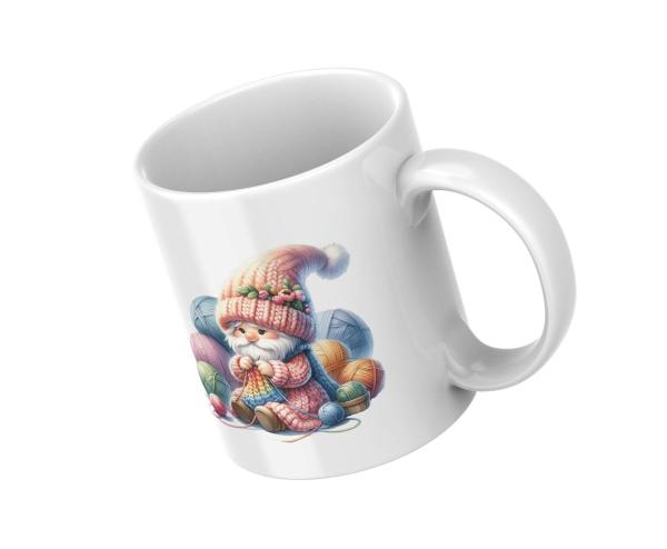 Weißer Keramikbecher mit einem Motiv eines niedlichen Gnoms in einer bunten Strickmütze, der mit bunten Garnknäueln strickt. Ein ideales Geschenk für Handarbeitsfans und kreative Seelen.
