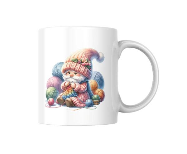 Weißer Keramikbecher mit einem Motiv eines süßen Gnoms in einer Strickmütze, der von bunten Garnknäueln umgeben ist und ein Strickprojekt in den Händen hält. Perfektes Geschenk für kreative Strick- und Handarbeitsliebhaber.