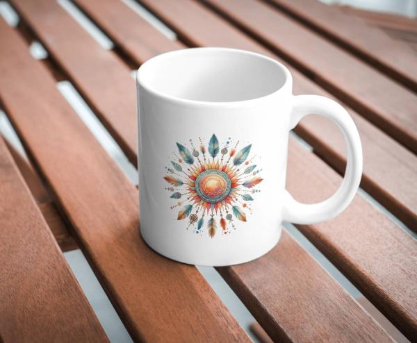 Weißer Keramikbecher mit einem detailreichen Boho-Sonnenmotiv, umgeben von bunten Federn und spirituellen Symbolen in warmen Farben, ideal für Liebhaber von Ethno- und Sonnen-Designs.