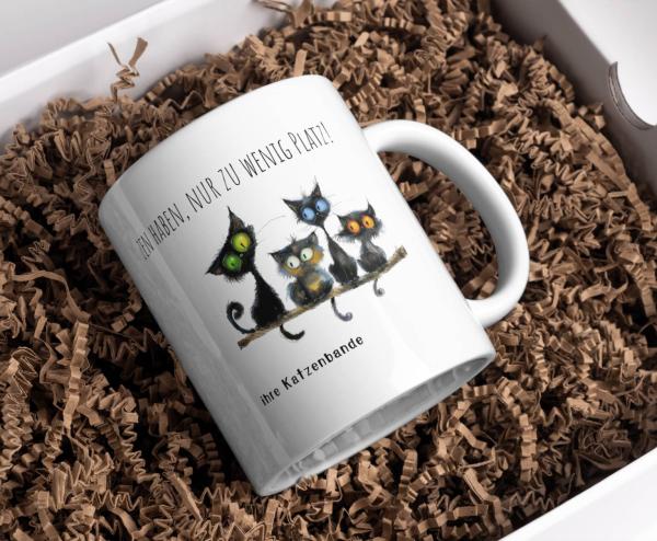 Tasse mit lustigem Spruch für Katzenfreunde: 'Man kann nie zu viele Katzen haben, nur zu wenig Platz!' und Personalisierung 'ihre Katzenbande'. Vier schwarze Katzen auf einem Ast sorgen für ein charmantes Design.