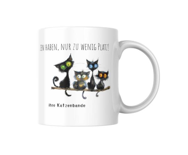 Weiße Tasse mit dem humorvollen Spruch 'Man kann nie zu viele Katzen haben, nur zu wenig Platz!' und Personalisierung 'ihre Katzenbande'. Vier süße schwarze Katzen mit großen Augen sitzen auf einem Ast.
