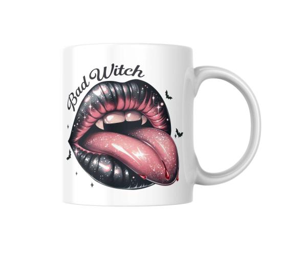 Weiße Keramiktasse mit dem Halloween-Design 'Bad Witch'. Das Motiv zeigt große, glänzende schwarze Lippen mit einer herausgestreckten, funkelnden rosa Zunge, umgeben von kleinen Fledermäusen. Der Schriftzug 'Bad Witch' ist darüber angebracht, ideal für Ha