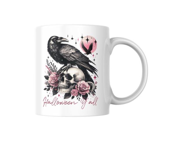 Weiße Tasse mit Halloween-Design: Ein detailreicher schwarzer Rabe sitzt auf einem Totenkopf, der von rosafarbenen Rosen und Blättern umgeben ist. Im Hintergrund ist ein rosa Mond zu sehen, vor dem ein fliegender Rabe erscheint. Der Schriftzug 'Halloween